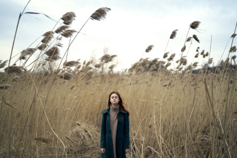 Caucasian woman standing in field with eyes closed