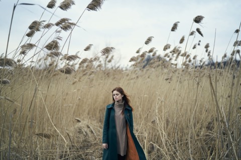 Pensive Caucasian woman standing in field