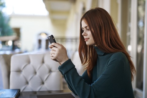 Caucasian woman texting on cell phone at restaurant