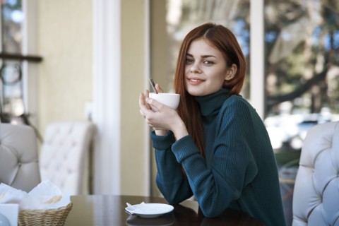 Caucasian woman drinking coffee at restaurant