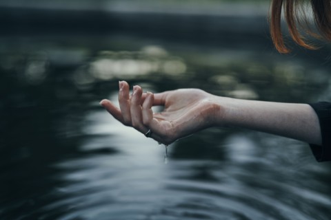 Water dripping from hand of woman