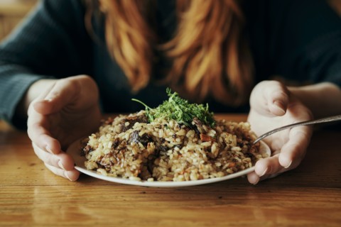 Hands of woman holding a plate of rice