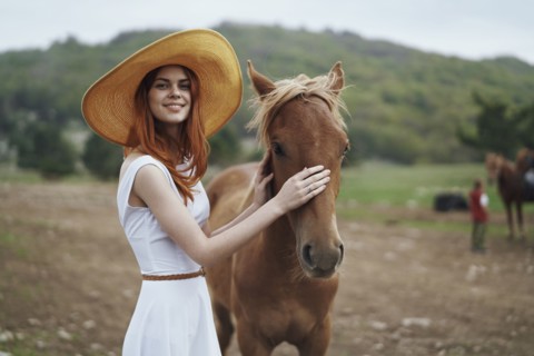 Smiling woman petting horse