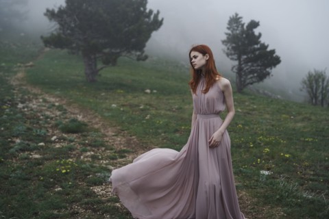 Caucasian woman wearing a dress in field