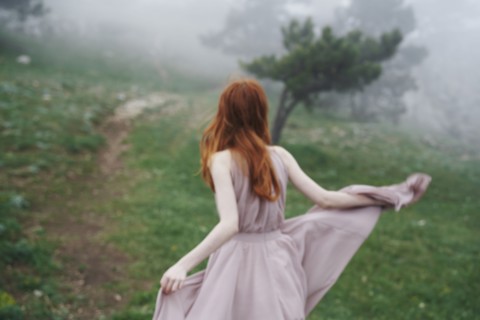 Caucasian woman wearing a dress in field