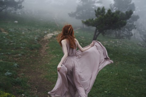 Caucasian woman wearing a dress in field
