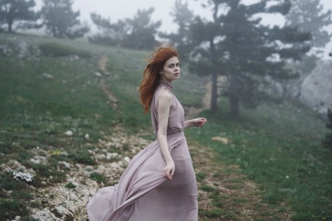 Wind blowing hair of Caucasian woman in field