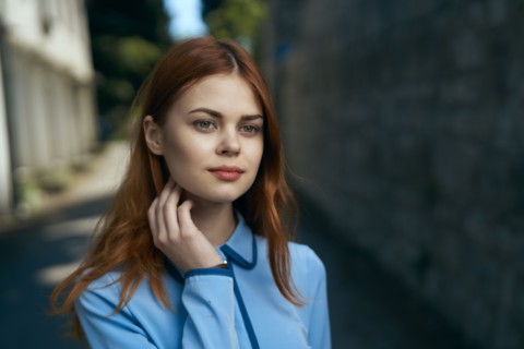 Pensive Caucasian woman near stone wall