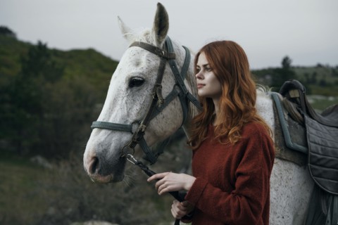Caucasian woman holding rein of horse
