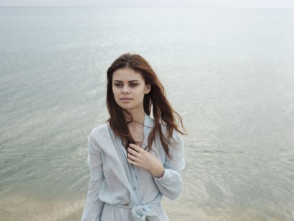 Serious Caucasian woman standing near ocean