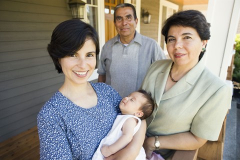 Portrait of mother with sleeping baby and grandparents