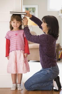Mother measuring daughter's height