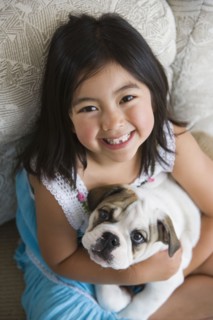 High angle view of young Asian girl holding puppy