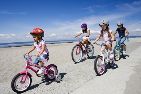 Young girls riding bicycles at beach