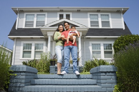 Portrait of Hispanic family in front of house