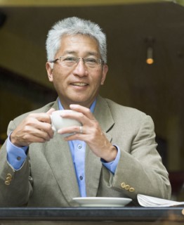 Senior Asian businessman holding cup of coffee