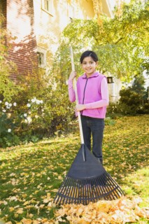 Hispanic girl raking leaves
