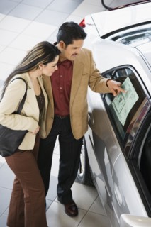 Hispanic couple looking at new car