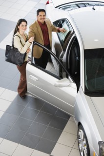 Hispanic couple looking at new car