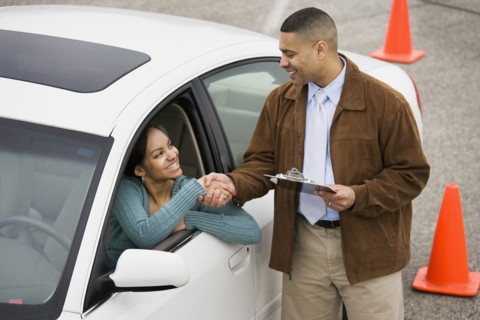 African teenager shaking hands with driving instructor
