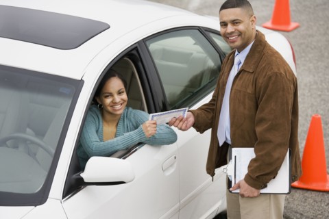 African teenager receiving drivers test certificate