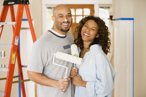 African couple being silly with paint rollers