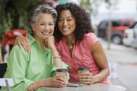 African American mother and adult daughter hugging