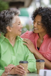 African American mother and adult daughter smiling at each other