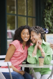 African American mother and adult daughter hugging