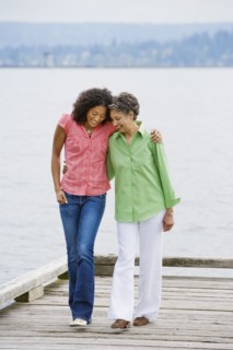 African American mother and adult daughter walking on pier