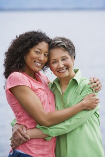 African American mother and adult daughter hugging