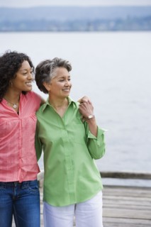African American mother and adult daughter hugging
