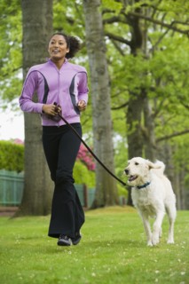 African American woman jogging with dog