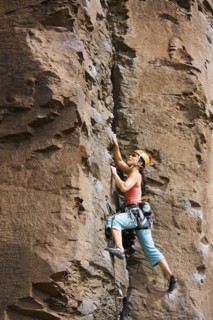 Asian woman rock climbing