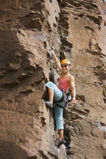 Asian woman rock climbing