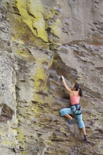 Asian woman rock climbing