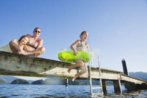 Asian girl jumping in lake