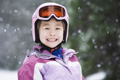 Asian girl wearing ski gear in snow
