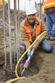 Hispanic construction worker holding equipment