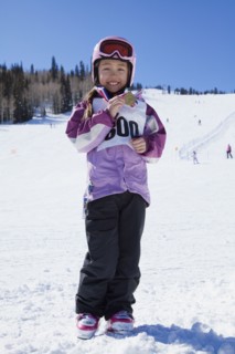 Mixed race girl showing off skiing medal