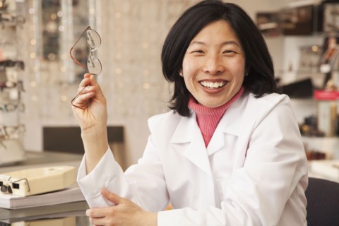 Korean optician holding eyeglasses