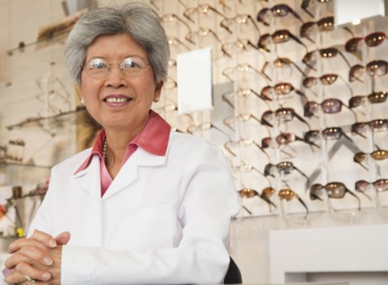 Chinese optician standing in store