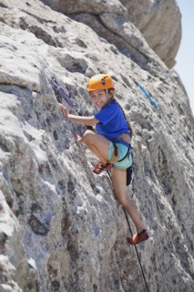 Mixed race girl rock climbing