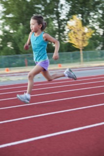 Mixed race girl running on track