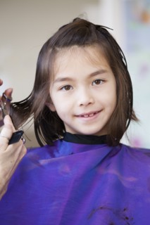 Mixed race girl getting her hair cut