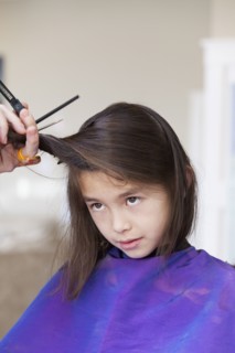 Mixed race girl getting her hair cut