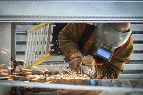 Construction worker grinding metal