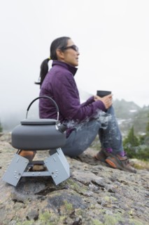 Japanese woman drinking coffee at campsite
