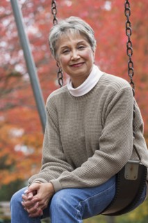 Mixed race woman on swing in park