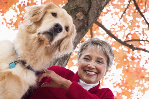 Mixed race woman with dog in park